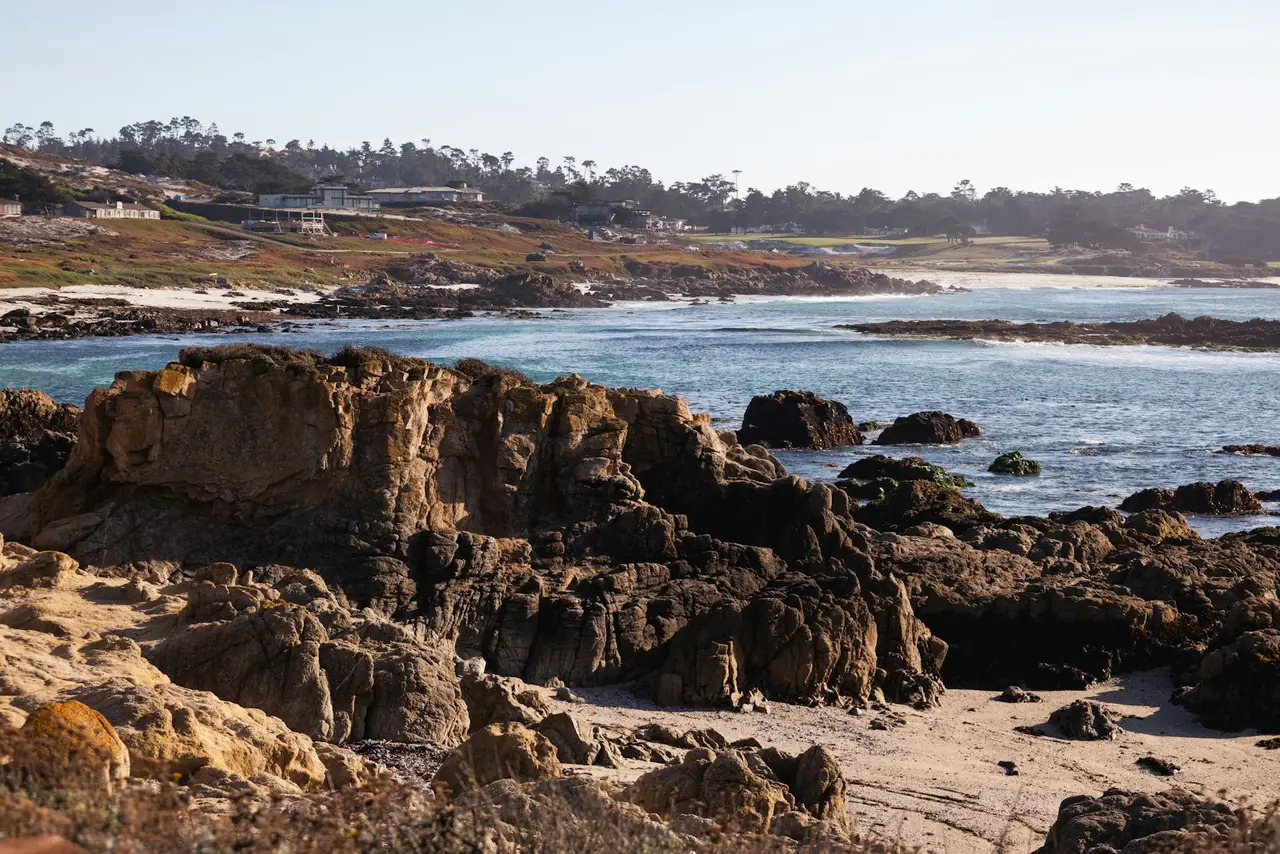Golfer on a California course with ocean and hills in the background